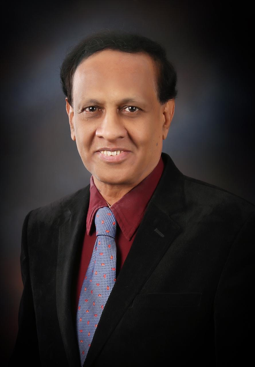 Studio portrait of Dr. D. A. Satish in a dark blazer and tie.